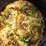 Overhead view of chicken marsala in a crockpot topped with fresh parsley and prosciutto.