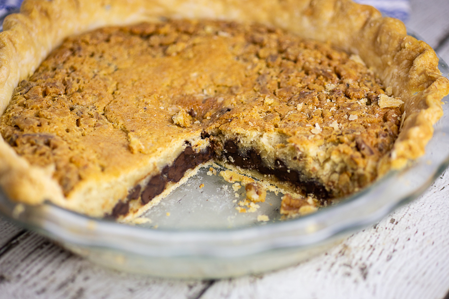 Glass Pie plate of Kentucky Derby Pie with large slice missing