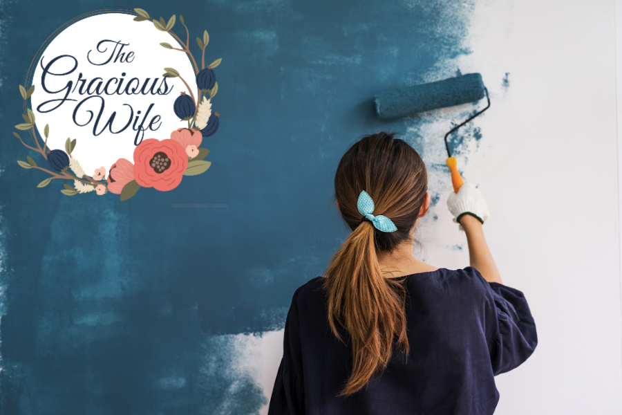 Girl with ponytail painting a wall with a paint roller