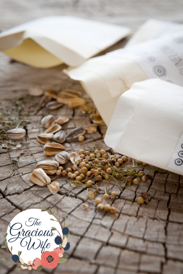 Brown packets of seeds laying out on rustic wood