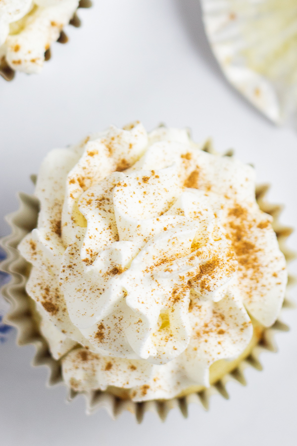 Overhead picture of a cupcake topped with Whipped Mascarpone Frosting and a sprinkle of cinnamon