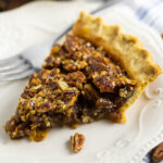 Southern pecan pie on a white plate with a fork