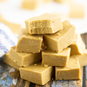 Stack of peanut butter fudge on a blue rustic wood background