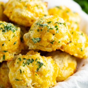 Cheddar Bay Biscuits in a white linen with parsley in the background