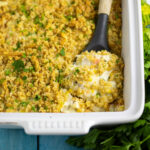 Ritz cracker chicken casserole in a white casserole dish with a wooden spoon in it