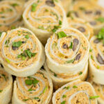 Close up of a stack of Mexican pinwheels topped with freshly chopped cilantro.