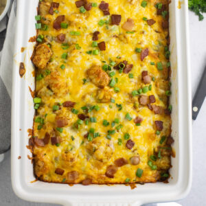 Overhead view of tater tot breakfast casserole topped with crumbled bacon and green onions.