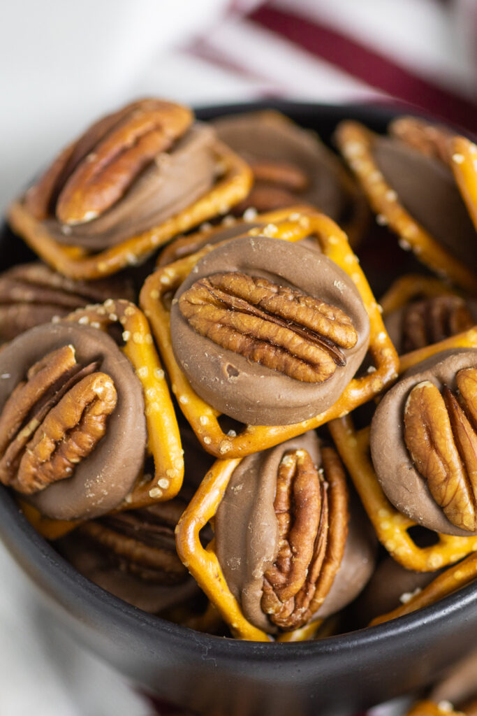 Rolo Pretzel Turtles piled in a small bowl with a linen napkin behind.