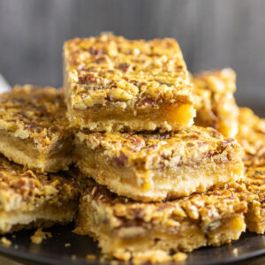 Southern Pecan Pie bars piled high on a plate.