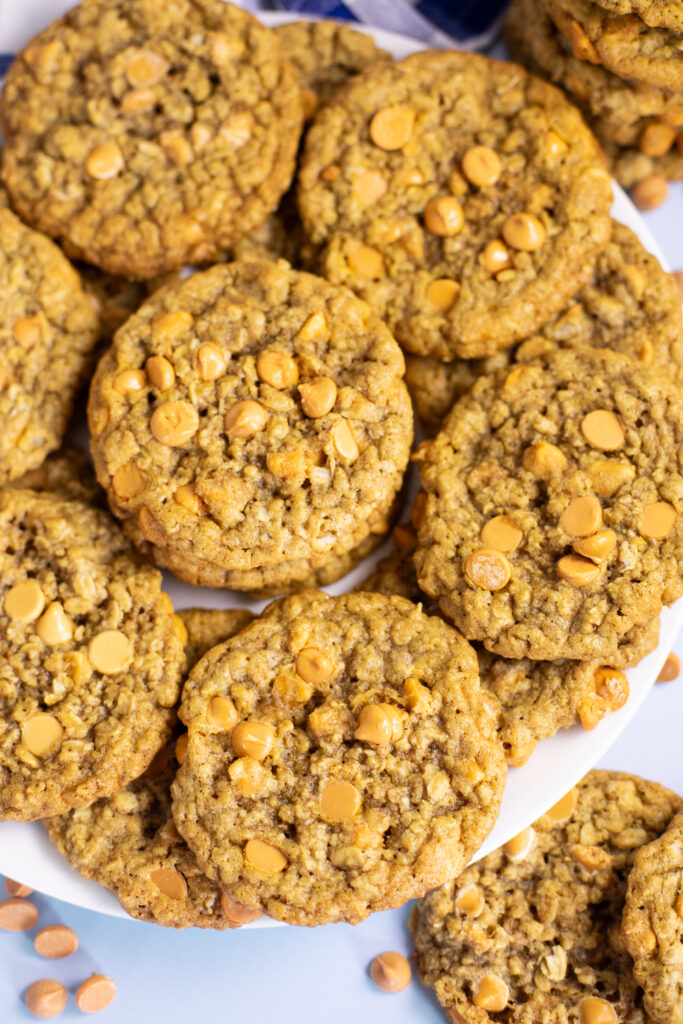 Overhead view of oatmeal scotchies piled on a white plate.