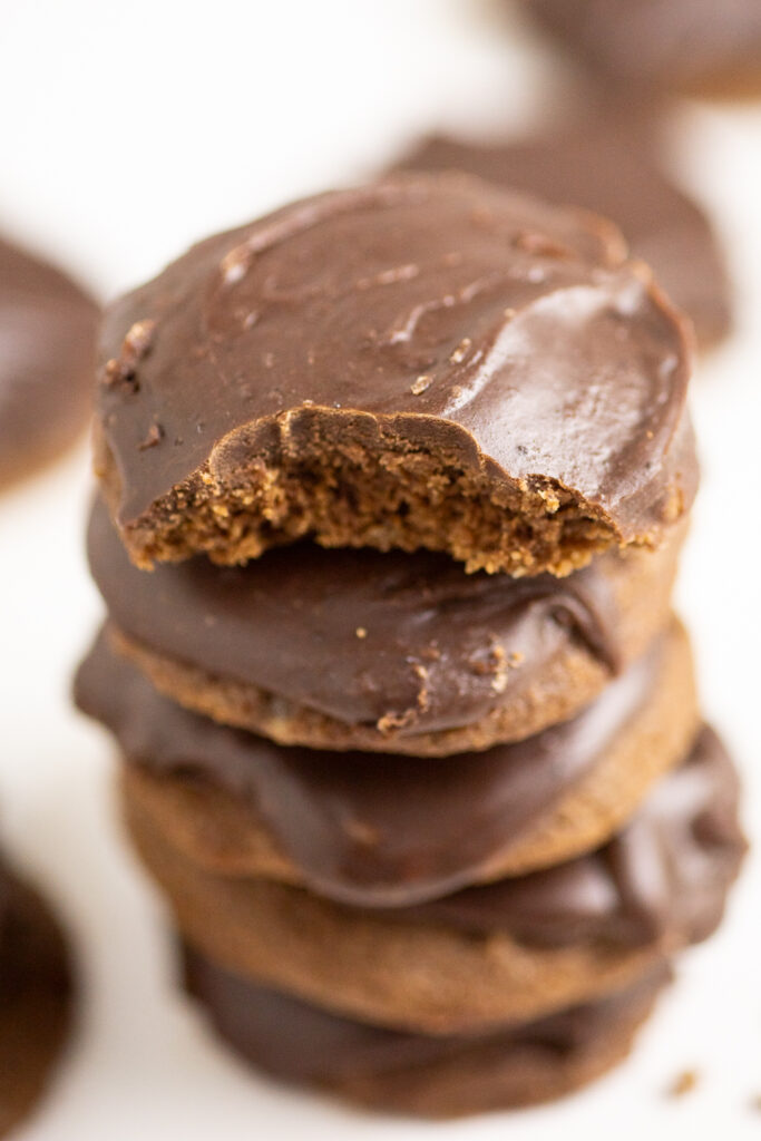 A stack of chocolate Texas sheet cake cookies with a bite taken out of the top one.