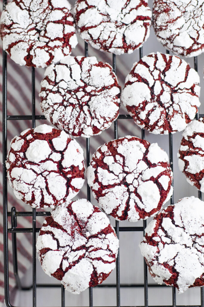 Overhead view of red velvet crinkle cookies on a wire cooling rack.